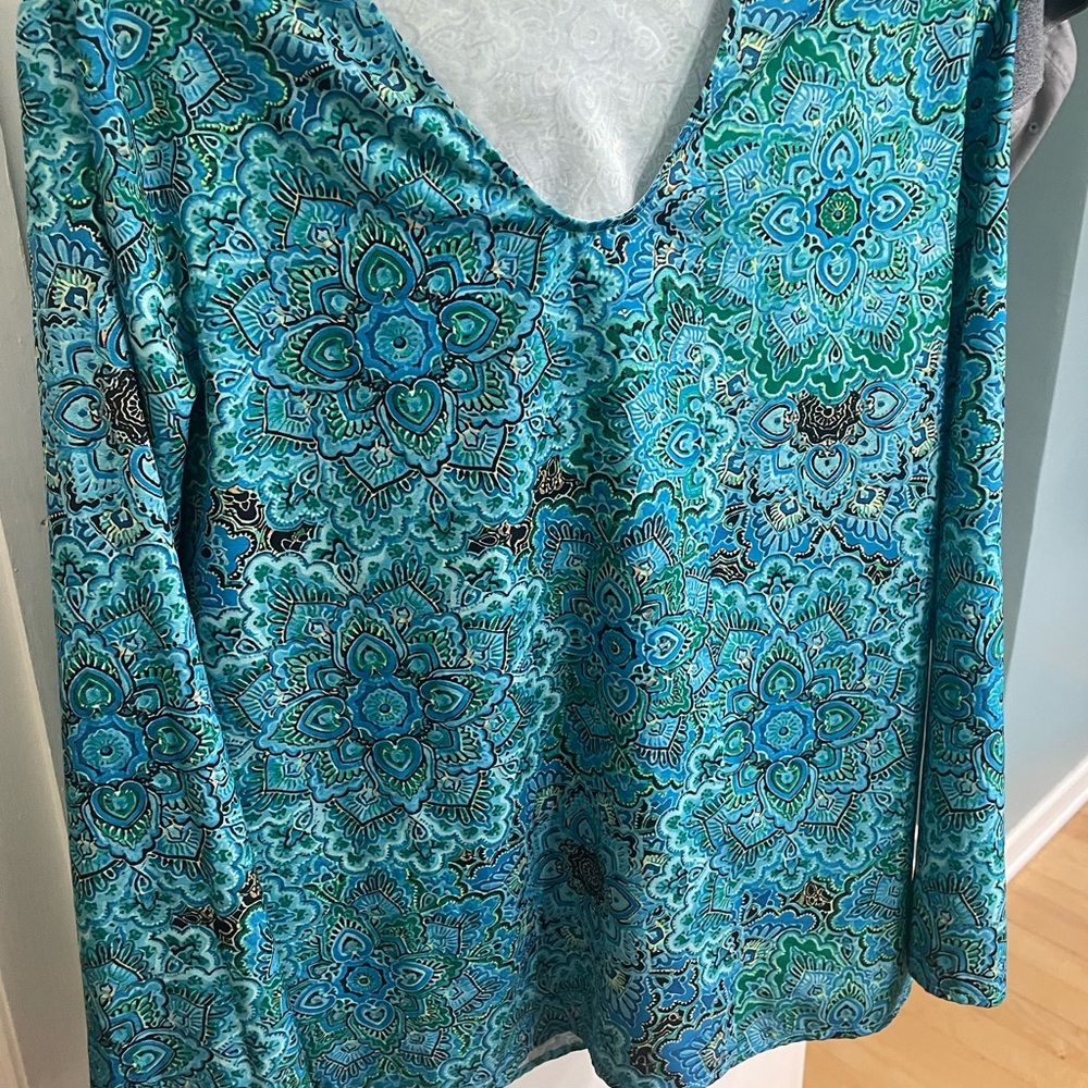 Cute stylish top with beautiful turquoise colors but too snug in my breast .